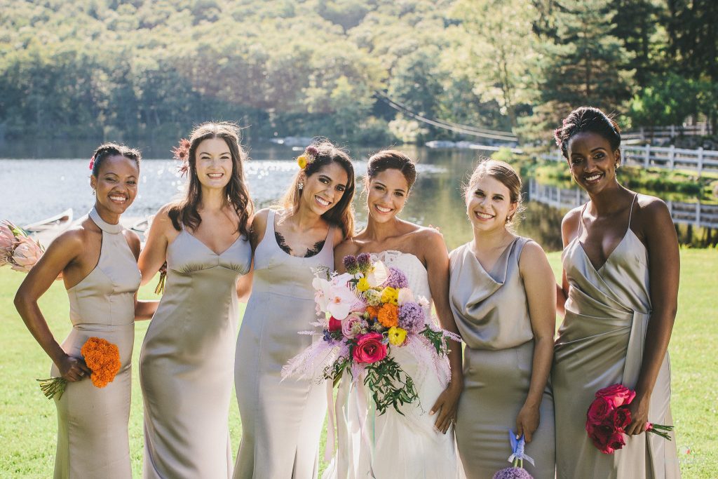 wedding party portrait of bride and bridesmaids with lake and countryside vista