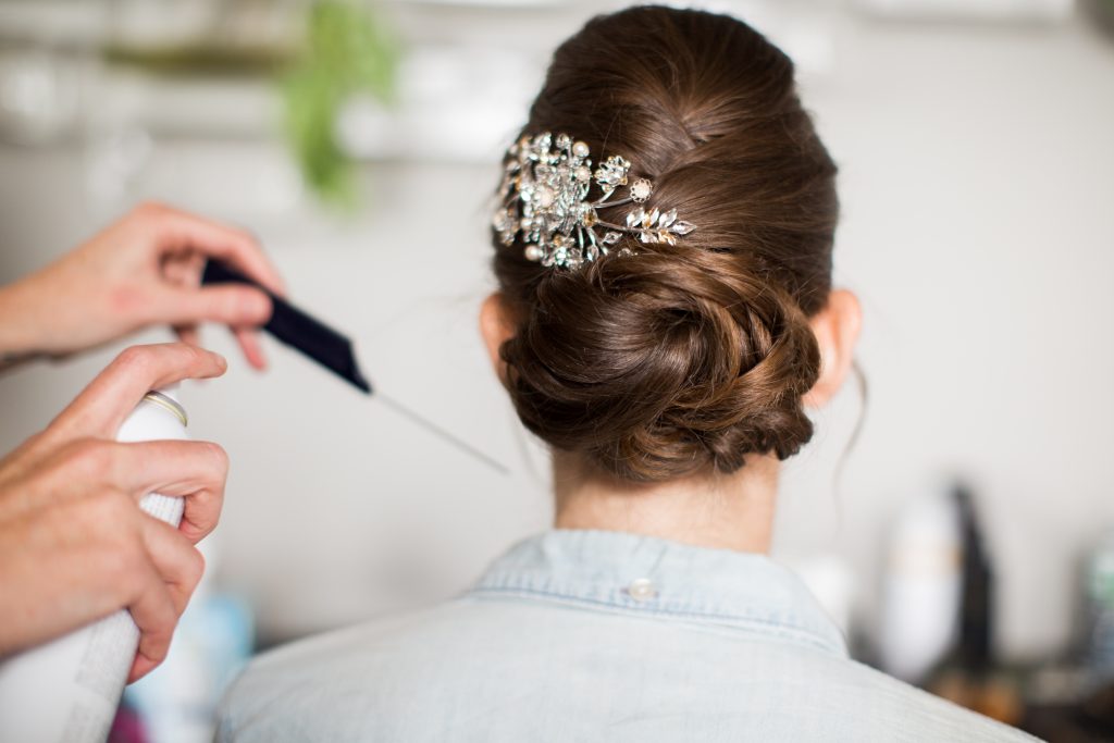 Bridal up-do with textured hair pulled into a bun, adorned with floral sparkly hair accessory