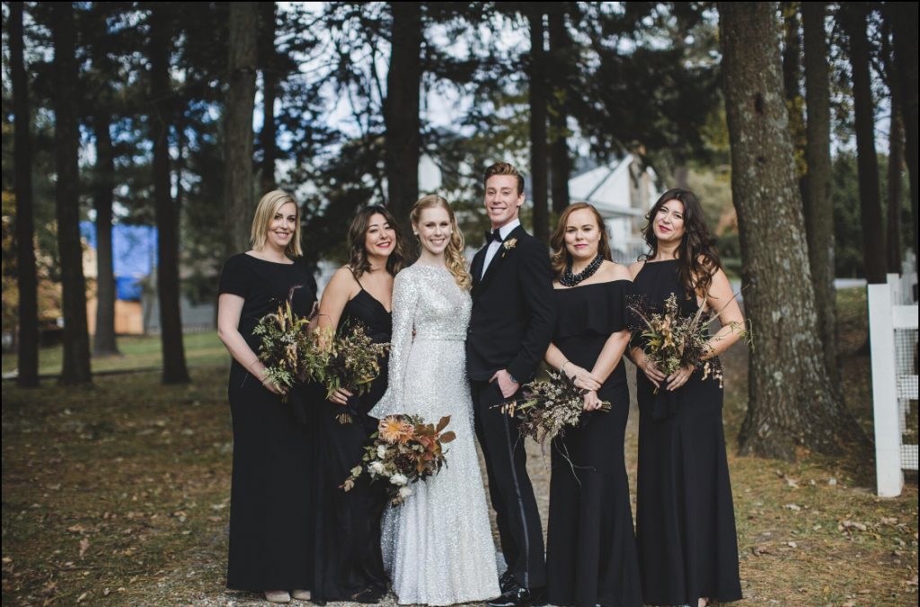 Wedding portrait, wedding party, bridesmaids, bride in white sparkly gown. Woods in background. 