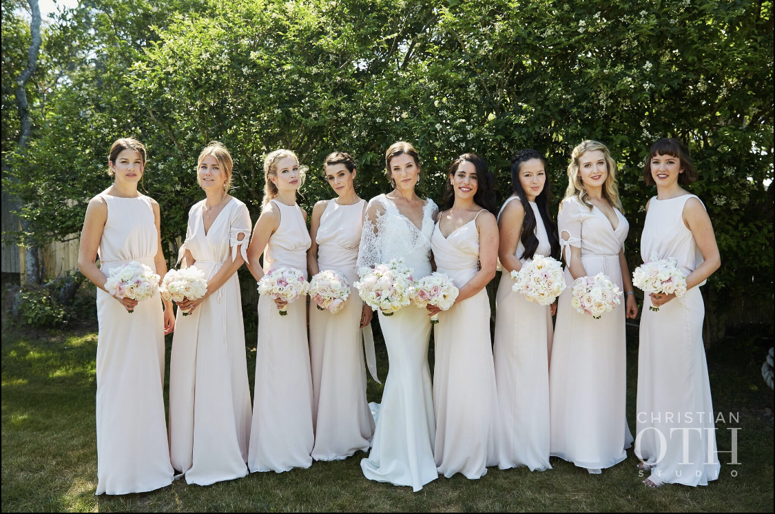 Bride with her seven bridesmaids, all with different hairstyles, posing at Crow's Nest in Montauk