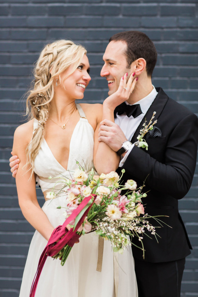 Cool modern bride with romantic braid in her blonde hair, pictured with groom at Wythe Hotel in Brooklyn