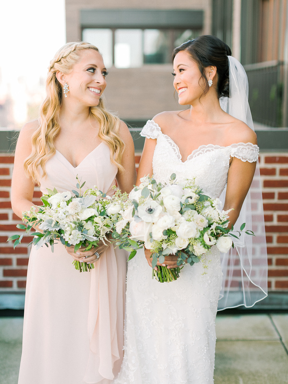 Bridesmaid with wavy blonde hair and bride with modern updo