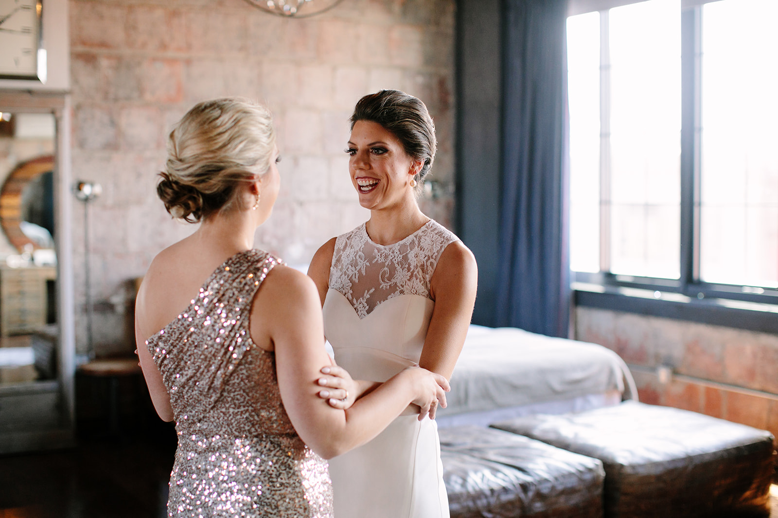 Bride and sister, both with chic modern updos, pictured at the Paper Factory Hotel in Long Island City