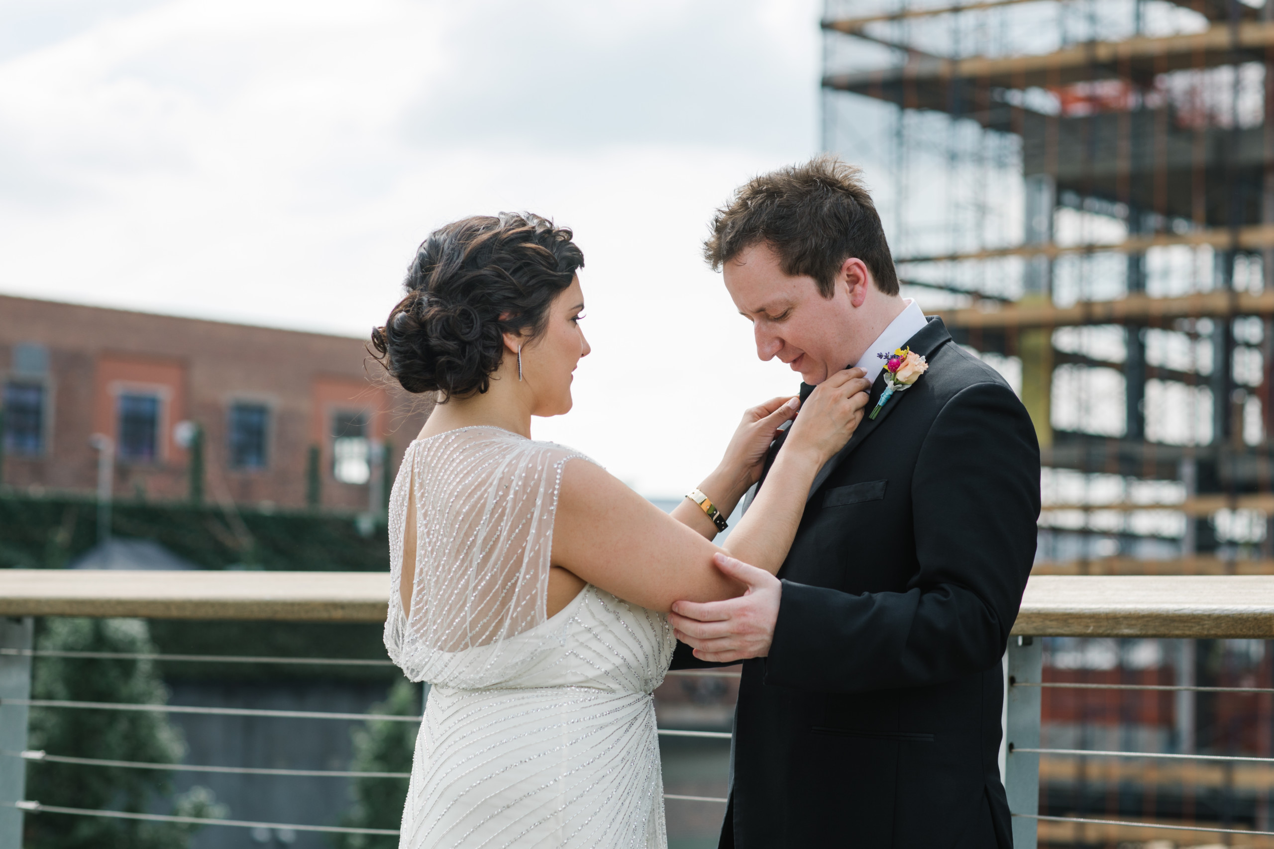 Bride with dark shiny curly hair styled with natural texture in a low chic chignon, pictured at they Wythe Hotel, Brooklyn